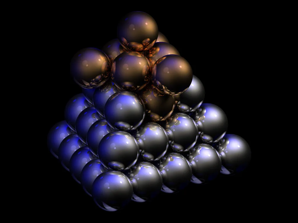A pyramid of shiny metal spheres stacked on a black background.
